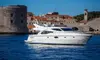 Luxury yacht sailing past Dubrovnik old town walls, Croatia. 