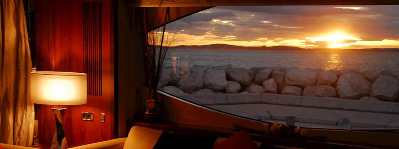 Luxurious yacht interior with comfortable seating and sunset view through window
