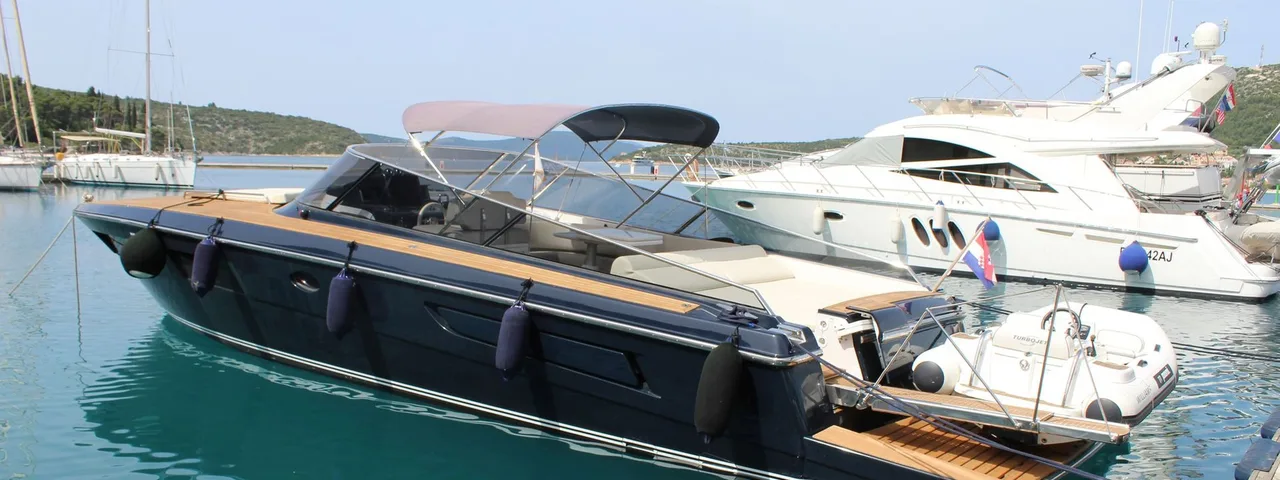 Luxury yacht ITAMA 45 moored in Dubrovnik marina, surrounded by crystal-clear Adriatic waters and lush coastal landscape