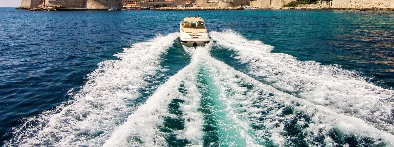 Speedboat leaving Dubrovnik Old Town harbor. Explore the Adriatic with Tendo.
