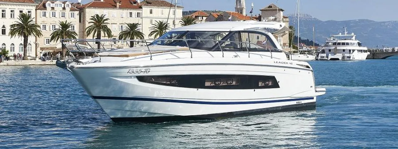 Luxury yacht cruising along Dubrovnik's picturesque coastline, with historic architecture and palm trees in the background