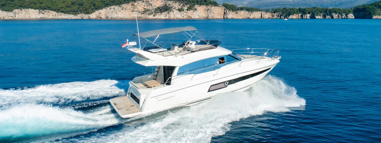 Luxury yacht from our fleet cruising through crystal-clear blue waters near Dubrovnik on a sunny day.