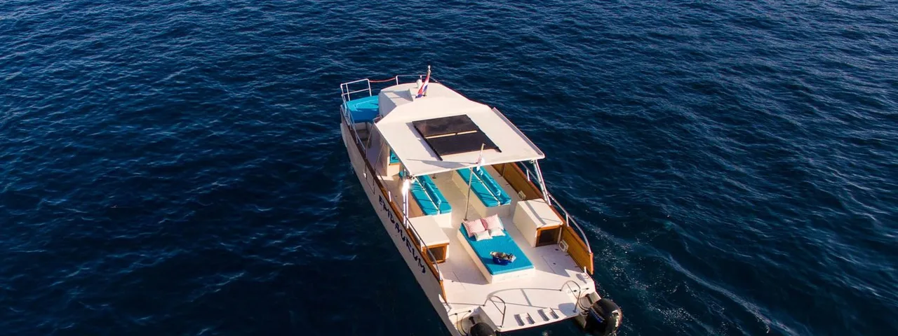 Luxury catamaran glides to Dubrovnik Elafiti islands, leaving a white wake. Ideal for yacht charters & serene sea travel.