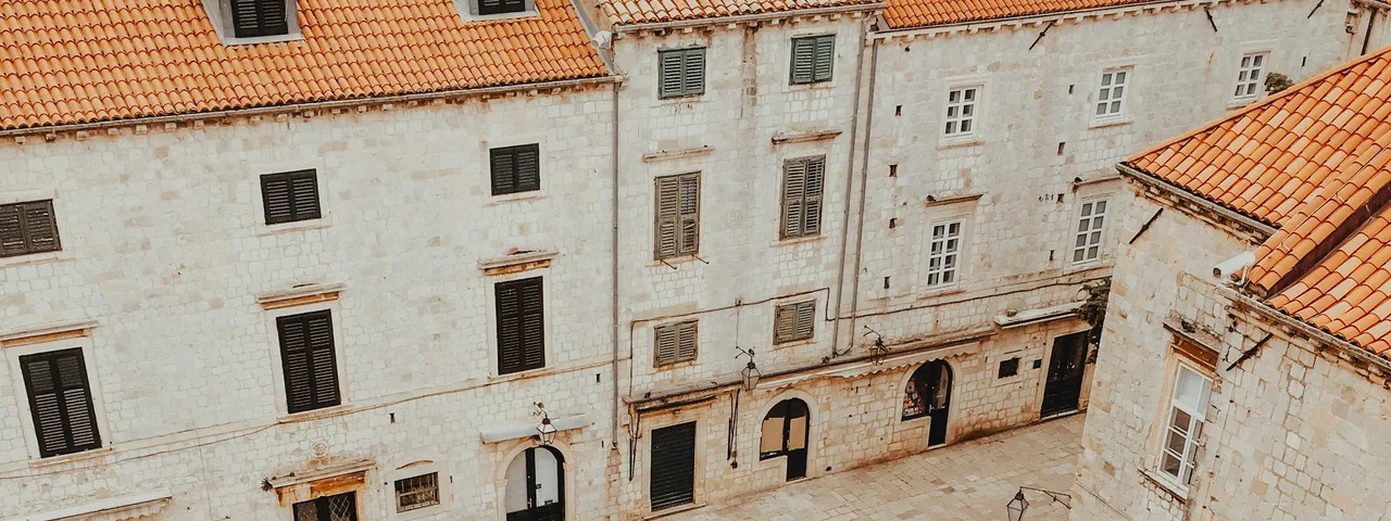 View from Dubrovnik city walls looking down the Stradun main street lined with pedestrians and baroque facades, Croatia