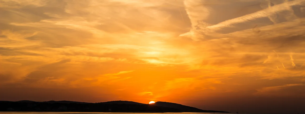Golden sunset over Dubrovnik old town walls and Adriatic Sea viewed from hilltop trail