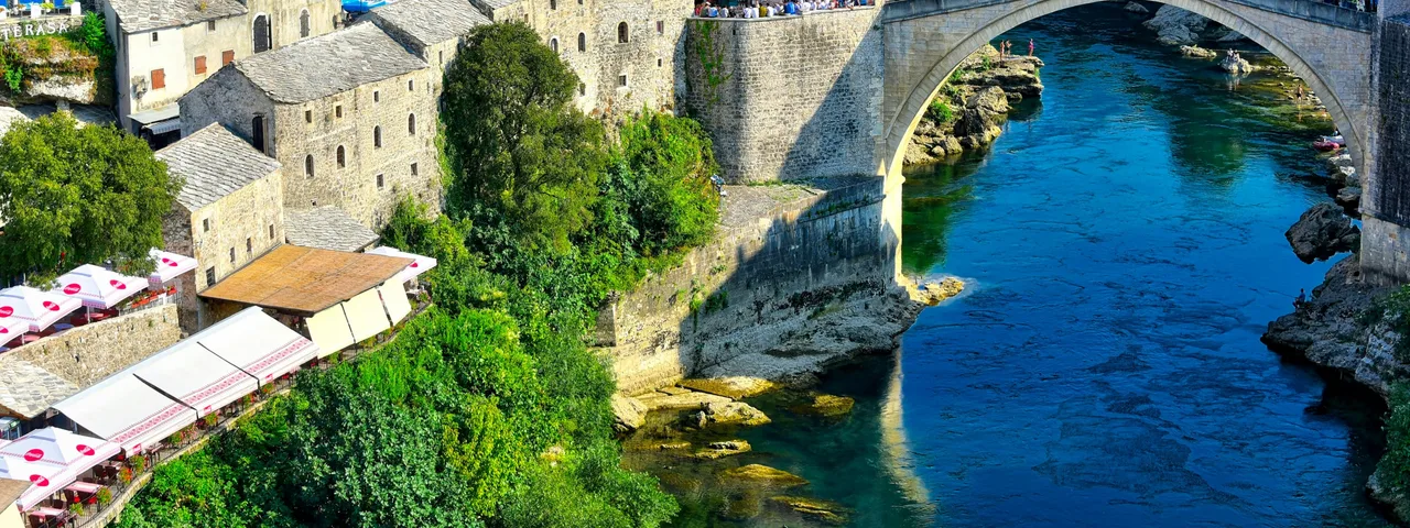 Stari Most Ottoman bridge over Neretva River with Mostar old town stone towers in background
