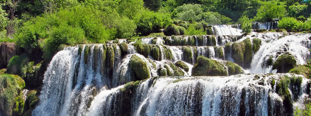 Multi-tiered Skradinski Buk waterfall with white rushing water over moss-covered travertine rocks in Krka National Park, Croatia