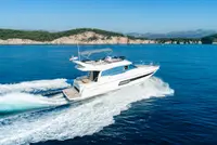 Luxury yacht from our fleet cruising through crystal-clear blue waters near Dubrovnik on a sunny day.