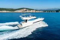 Luxury yacht from our fleet cruising through crystal-clear blue waters near Dubrovnik on a sunny day.