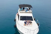 Aerial view of a luxury yacht charter cruising the crystal-clear turquoise waters of the Dubrovnik Elaphite Islands. A small group of friends or family enjoys a private boat tour, surrounded by stunning islands, perfect for an exclusive island hopping adventure or premium Dubrovnik vacation.