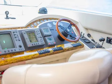Luxury yacht control panel with modern navigation equipment and wooden steering wheel, ready for Dubrovnik Private Boat Tours