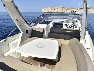 Luxury speedboat interior with spacious seating, dining table, and open cockpit, perfect for Dubrovnik day trips.