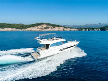 Luxury yacht from our fleet cruising through crystal-clear blue waters near Dubrovnik on a sunny day.