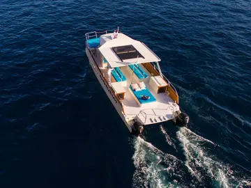 Luxury catamaran glides to Dubrovnik Elafiti islands, leaving a white wake. Ideal for yacht charters & serene sea travel.