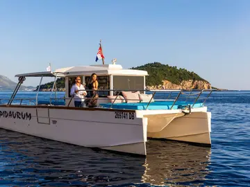 Luxury catamaran 'Epidaurum' on calm blue sea in front of Lokrum island. Perfect for Croatia yacht charters.