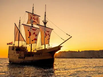 Dubrovnik luxury event ship sailing at sunset beside the Old Town city walls