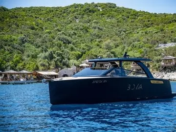 Luxury motor yacht on clear blue water near Dubrovnik island Sipan, waiting for clients in front of popular Bowa restaurant.