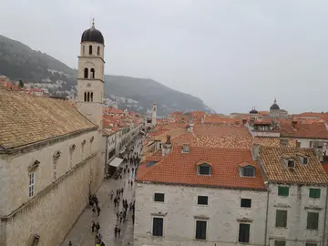 Ancient stone tower and rampart of Dubrovnik city walls rising above limestone buildings in the Old Town, Croatia