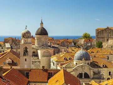 Panoramic aerial view of Dubrovnik Old Town terracotta rooftops, cathedral dome and blue Adriatic Sea, Croatia