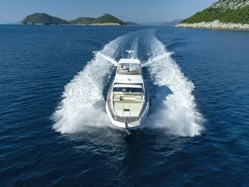 Azimut 66 Fly luxury yacht cruising the Adriatic Sea near Dubrovnik, leaving a powerful wake under a clear sky.