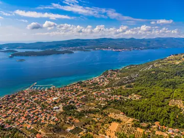 Aerial panorama of Korčula island and Pelješac channel with coastal village, olive groves and turquoise Adriatic Sea, Croatia