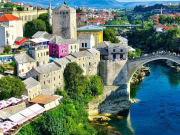 Stari Most Ottoman bridge over Neretva River with Mostar old town stone towers in background