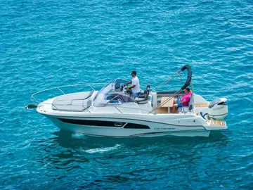 White Cap Camarat motorboat with Suzuki outboard engine cruising on crystal blue sea. Powerboat rental for summer vacation and coastal exploration.