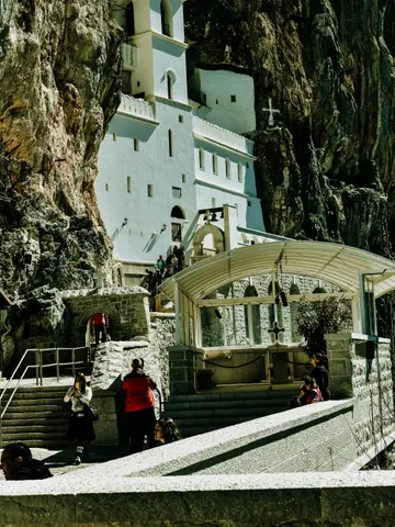 Ostrog Monastery — the white Serbian Orthodox pilgrimage church built into a vertical cliff face in the Montenegrin mountains