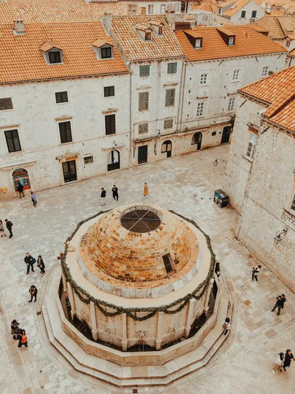 View from Dubrovnik city walls looking down the Stradun main street lined with pedestrians and baroque facades, Croatia