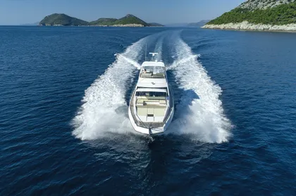 Azimut 66 Fly luxury yacht cruising the Adriatic Sea near Dubrovnik, leaving a powerful wake under a clear sky.