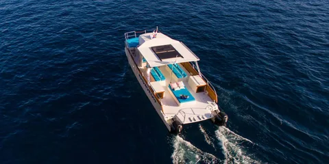 Luxury catamaran glides to Dubrovnik Elafiti islands, leaving a white wake. Ideal for yacht charters & serene sea travel.