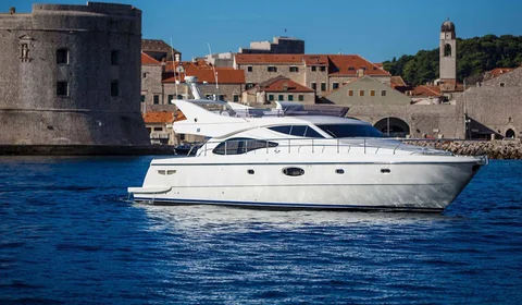 Luxury yacht sailing past Dubrovnik old town walls, Croatia. 