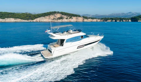 Luxury yacht from our fleet cruising through crystal-clear blue waters near Dubrovnik on a sunny day.