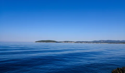 On the way from Dubrovnik to Hvar experience calm blue sea with distant islands on horizon under clear sky