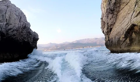 Scenic boat journey through rocky coastal formations near Dubrovnik, showcasing crystal-clear Adriatic waters