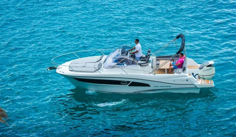 White Cap Camarat motorboat with Suzuki outboard engine cruising on crystal blue sea. Powerboat rental for summer vacation and coastal exploration.