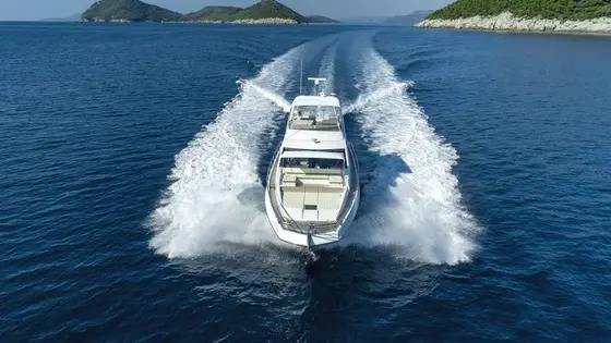 Azimut 66 Fly luxury yacht cruising the Adriatic Sea near Dubrovnik, leaving a powerful wake under a clear sky.