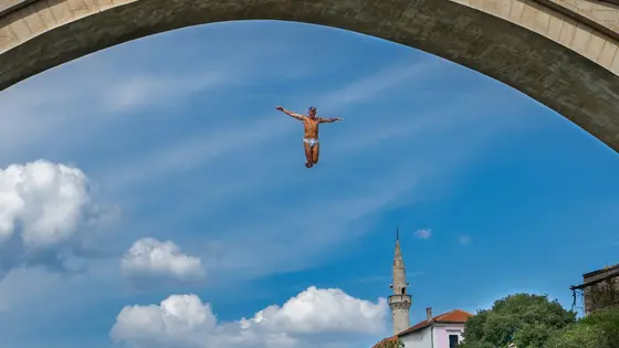 Divers jumping off Stari Most bridge into the Neretva River in Mostar, Bosnia and Herzegovina