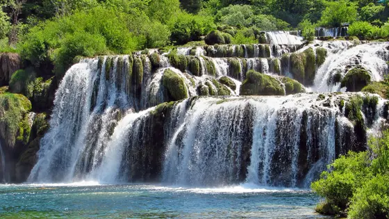 Multi-tiered Skradinski Buk waterfall with white rushing water over moss-covered travertine rocks in Krka National Park, Croatia