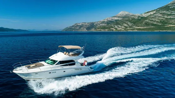 Luxury yacht cruising along Croatian coast near Dubrovnik, with Elaphiti islands and clear blue Adriatic Sea in background
