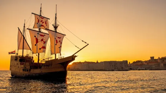 Dubrovnik luxury event ship sailing at sunset beside the Old Town city walls