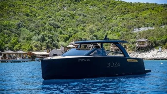 Luxury motor yacht on clear blue water near Dubrovnik island Sipan, waiting for clients in front of popular Bowa restaurant.