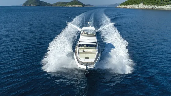 Azimut 66 Fly luxury yacht cruising the Adriatic Sea near Dubrovnik, leaving a powerful wake under a clear sky.
