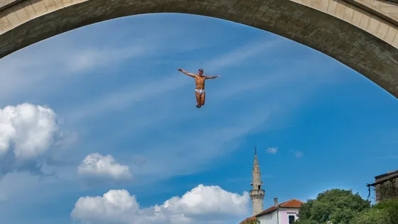 Divers jumping off Stari Most bridge into the Neretva River in Mostar, Bosnia and Herzegovina