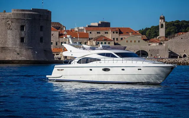 Luxury yacht sailing past Dubrovnik old town walls, Croatia.