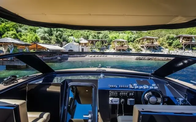 Luxury yacht cockpit view of serene coastal resort with bungalows & clear water, perfect for luxury Dubrovnik escape to islands.