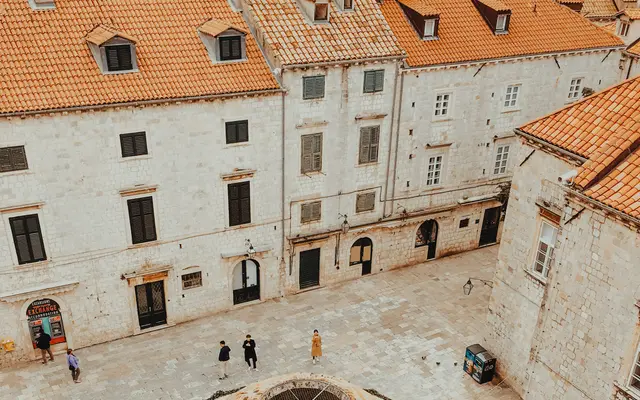 View from Dubrovnik city walls looking down the Stradun main street lined with pedestrians and baroque facades, Croatia