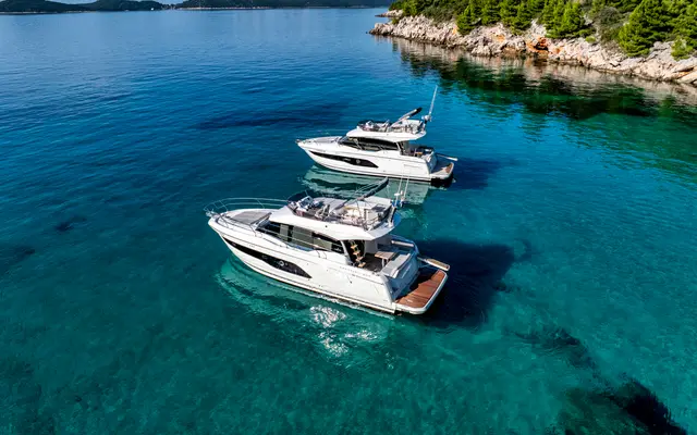 Luxury yacht charter in Croatia. Two Prestige 420 Tendo motor yachts on clear blue Adriatic Sea near Dubrovnik coastline.