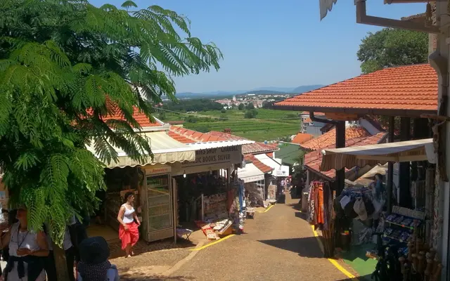 Pilgrim street in Medjugorje lined with souvenir and religious shops, valley view in background
