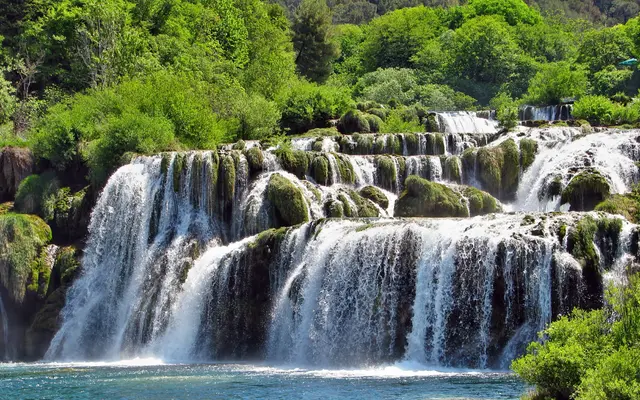 Multi-tiered Skradinski Buk waterfall with white rushing water over moss-covered travertine rocks in Krka National Park, Croatia
